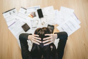Woman looking at mounting bills and debts, worried about being unable to pay her money lender in Singapore