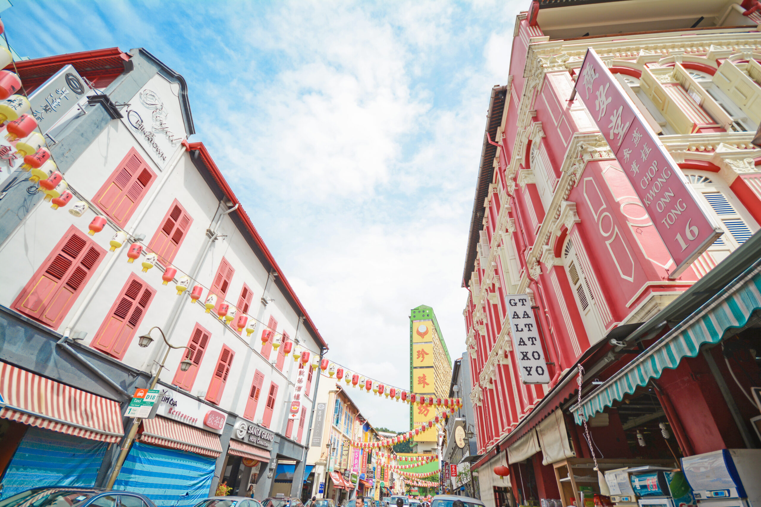 A panoramic shot of a stretch of shophouses with lantern decor in Chinatown